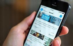 Person using a smartphone showing a digital community app interface with posts and profiles